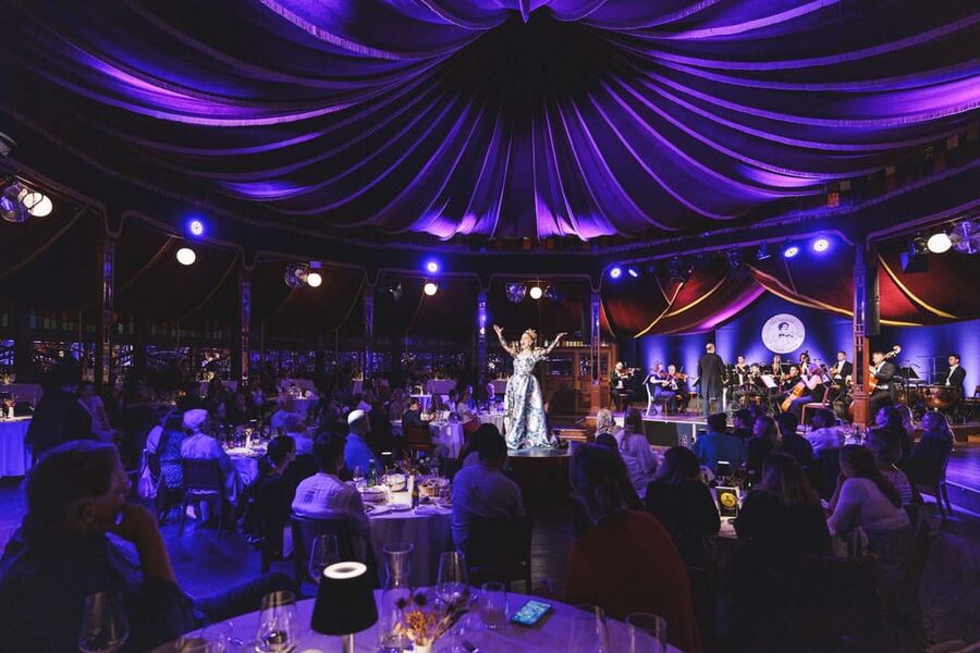 A Johann Strauss dinner show in Vienna, the ballroom lit from the stage